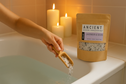 Person adding Himalayan salt to a bath with candles in the background